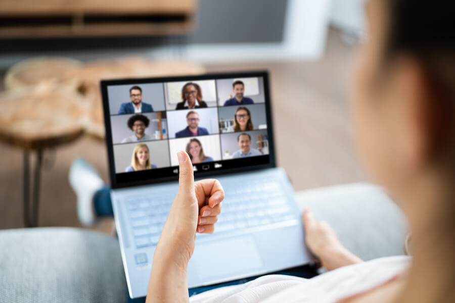 Remote worker giving screen of video-call attendees a thumbs up.