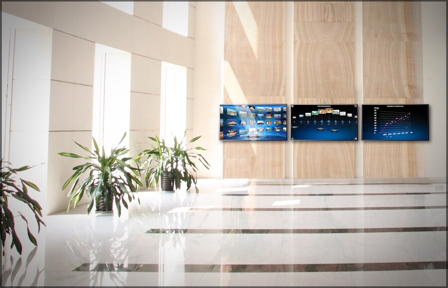 An office lobby with three visual displays mounted on the wall.